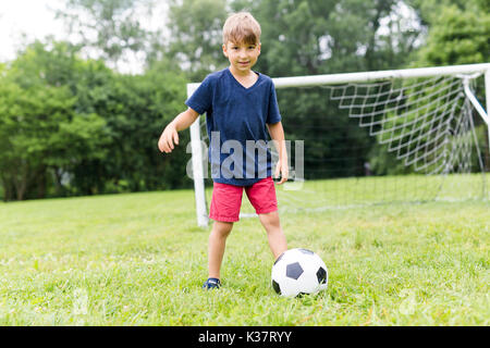 Junge mit Fußball auf einem Feld Spaß Stockfoto