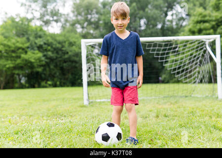 Junge mit Fußball auf einem Feld Spaß Stockfoto