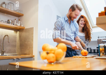 Paar, orange Smoothie in der Küche Stockfoto