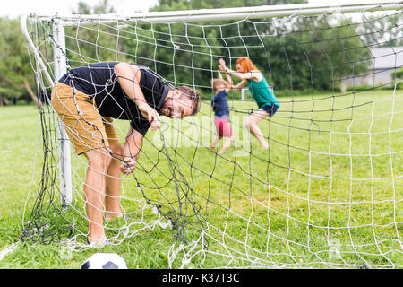 Freundliche Familie Fußball spielen in einem Park Stockfoto