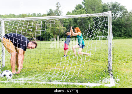Freundliche Familie Fußball spielen in einem Park Stockfoto