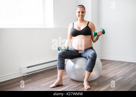 Schwangere Frau training mit Hanteln, aktiv zu bleiben Stockfoto