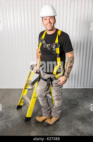 Arbeitnehmer mit einem Werkzeug Gürtel tragen weiße Helm Stockfoto