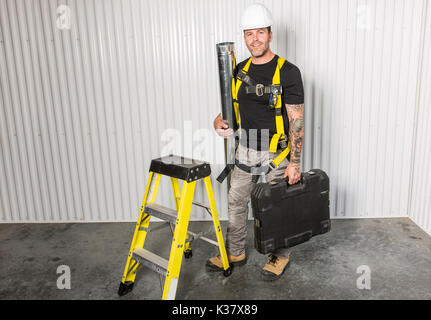 Arbeitnehmer mit einem Werkzeug Gürtel tragen weiße Helm Stockfoto
