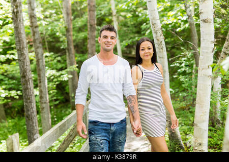 Junges Paar umschließt in einen Sommergarten Stockfoto