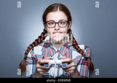 Nerd Frau mit Zopf Videospiele spielen mit einem Joypad Stockfoto