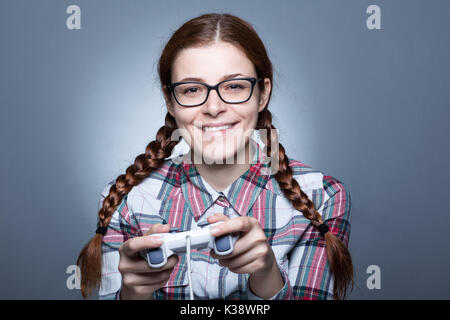 Nerd Frau mit Zopf Videospiele spielen mit einem Joypad Stockfoto