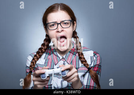 Nerd Frau mit Zopf Videospiele spielen mit einem Joypad Stockfoto