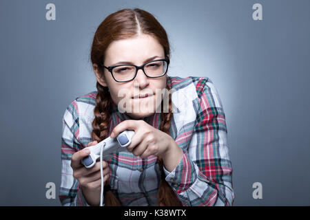 Nerd Frau mit Zopf Videospiele spielen mit einem Joypad Stockfoto