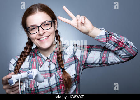 Nerd Frau mit Zopf Videospiele spielen mit einem Joypad Stockfoto