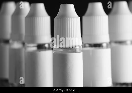 E liquid Flaschen für vaping Geräte, e Zigarette, elektronische Zigarette, über einem schwarzen Hintergrund. Stockfoto