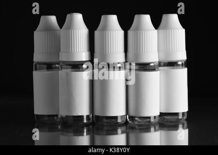 E liquid Flaschen für vaping Geräte, e Zigarette, elektronische Zigarette, über einem schwarzen Hintergrund. Stockfoto