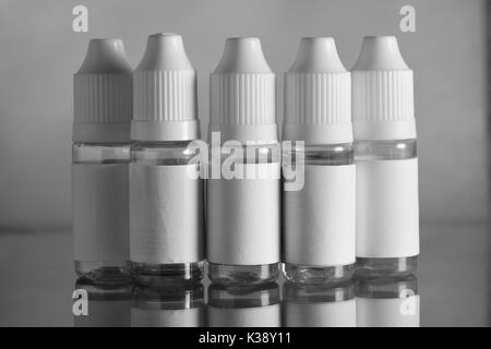 E liquid Flaschen für vaping Geräte, e Zigarette, elektronische Zigarette, über einem schwarzen Hintergrund. Stockfoto