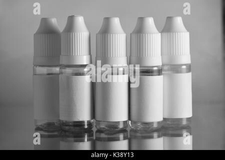 E liquid Flaschen für vaping Geräte, e Zigarette, elektronische Zigarette, über einem schwarzen Hintergrund. Stockfoto