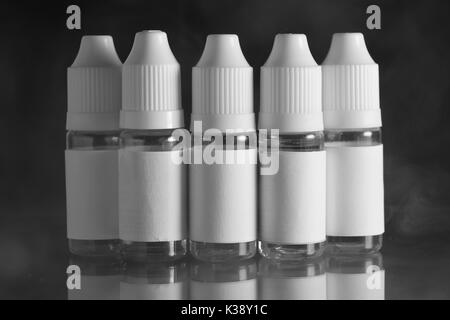 E liquid Flaschen für vaping Geräte, e Zigarette, elektronische Zigarette, über einem schwarzen Hintergrund. Stockfoto