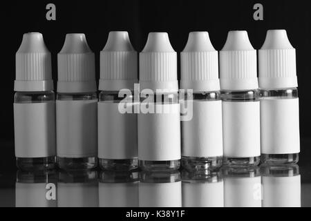 E liquid Flaschen für vaping Geräte, e Zigarette, elektronische Zigarette, über einem schwarzen Hintergrund. Stockfoto