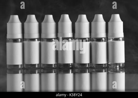 E liquid Flaschen für vaping Geräte, e Zigarette, elektronische Zigarette, über einem schwarzen Hintergrund. Stockfoto