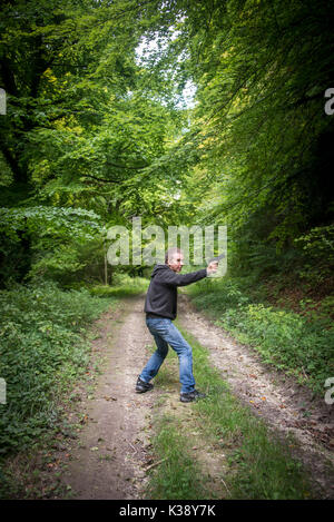 Der Mensch, der eine Waffe tragen ein Hoodie Stockfoto