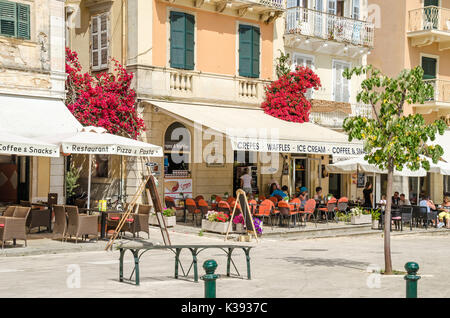 Korfu, Griechenland - Juni 7, 2017: Der Liston in Korfu, mit seinen eleganten Cafés, ein überfüllter, entspannt sitzen und Snack und dem Spaziergänger watch al Stockfoto