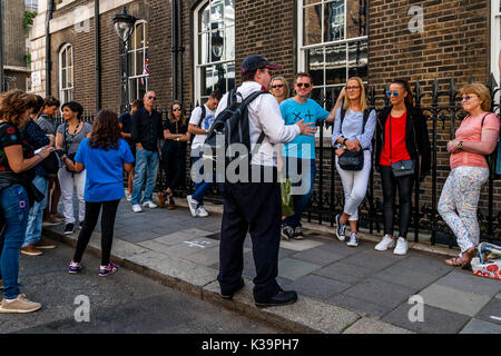 Touristen Hören zu einem London Tour Guide, Mayfair, London, Großbritannien Stockfoto