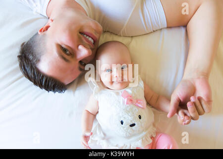 Portrait von Vater mit Ihrem 3 Monate alten Baby im Schlafzimmer Stockfoto