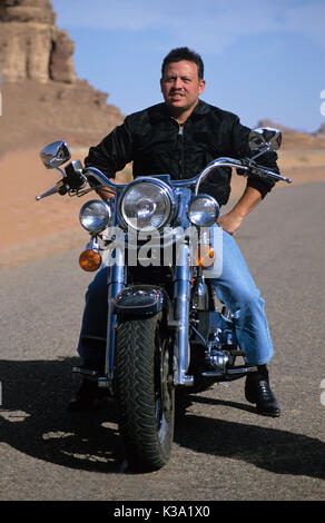 König Abdullah II von Jordanien reiten sein Motorrad im Wadi Rum, während Dreharbeiten Reisedokumentation Jordan: The Royal Tour ca. 2000 Stockfoto