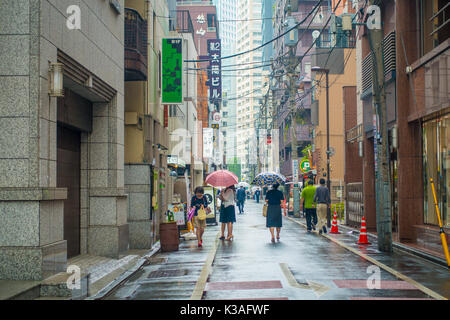 Tokio, Japan, 28. Juni - 2017: Nicht identifizierte Personen unter Sonnenschirmen auf Zebrastreifen Straße in Jimbocho Bezirk in Tokio Stockfoto