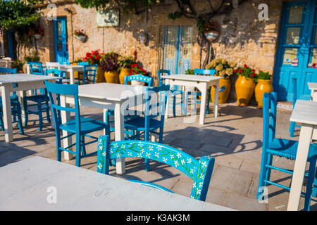 Tische und Stühle in einem traditionellen italienischen Restaurant in Marzamemi - Sizilien an einem sonnigen Tag Stockfoto