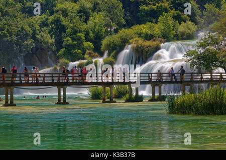 Touristen baden am Wasserfall Smotcycleinski Buk, Nationalpark Krka, Sibenik-Knin, Dalmatien, Kroatien Stockfoto