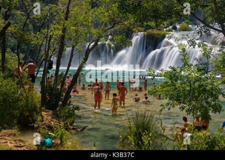 Touristen baden am Wasserfall Smotcycleinski Buk, Nationalpark Krka, Sibenik-Knin, Dalmatien, Kroatien Stockfoto