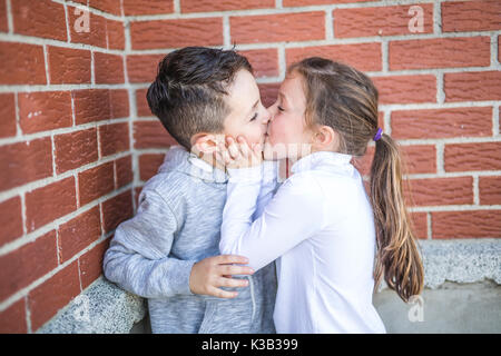 Erste Liebe und Küssen zwei Glückliche cute Kids treffen Stockfoto