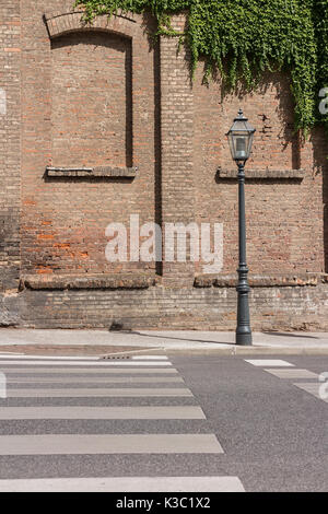 Altmodische Lamp Post vor alten Backsteingebäude mit Zugemauert Windows und einige Efeu Stockfoto