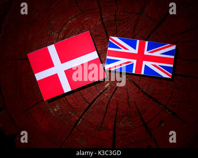 Dänische Flagge mit britischer Flagge auf einem Baumstumpf isoliert Stockfoto