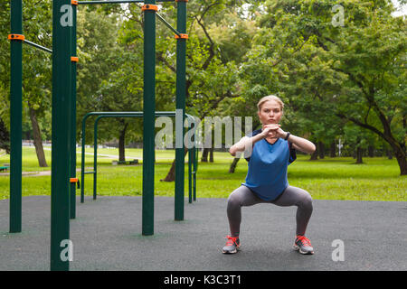 Schöne Mädchen dabei hockt Outdoor Sport Website Stockfoto