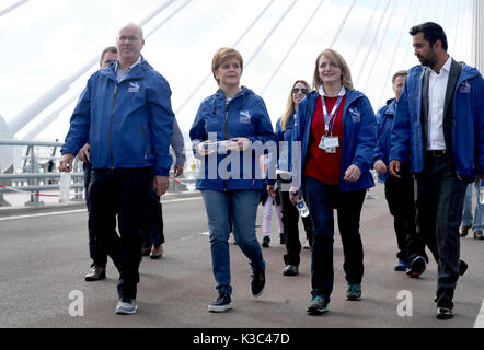 Erster Minister Nicola Sturgeon (Zweite links) Wettbewerb - Gewinner in die Queensferry Überfahrt in eine einmalige Chance ist, die neue Brücke zu Fuß zu überqueren. Stockfoto