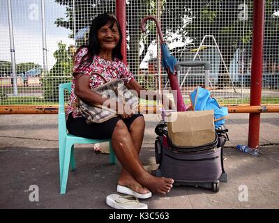MARIKINA CITY, Philippinen - 28. AUGUST 2017: einem Straßenhändler verkauft, Süßigkeiten und Zigaretten unter dem Schatten eines Dreirads terminal in Marikina City, Ph Stockfoto