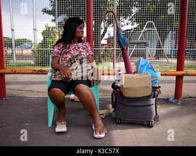 MARIKINA CITY, Philippinen - 28. AUGUST 2017: einem Straßenhändler verkauft, Süßigkeiten und Zigaretten unter dem Schatten eines Dreirads terminal in Marikina City, Ph Stockfoto