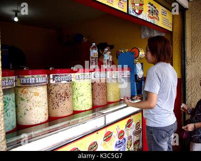MARIKINA CITY, Philippinen - 28. AUGUST 2017: Ein Kunde kauft, kalte Säfte aus einem Laden. Stockfoto