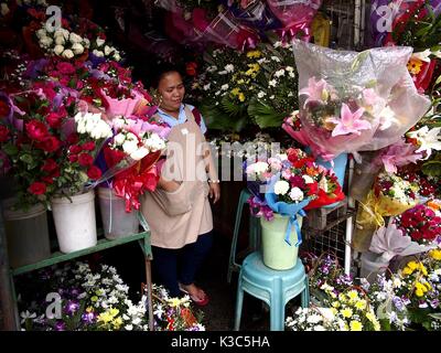 MARIKINA CITY, Philippinen - 28. AUGUST 2017: eine Frau verkauft bunt gemischte frische Blumen in ihrem Speicher. Stockfoto