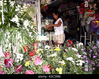 MARIKINA CITY, Philippinen - 28. AUGUST 2017: eine Frau verkauft bunt gemischte frische Blumen in ihrem Speicher. Stockfoto
