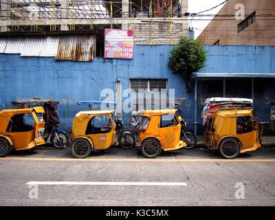 MARIKINA CITY, Philippinen - 28. AUGUST 2017: Gelb gefärbte Dreiräder an einem Terminal warten auf Passagiere geparkt. Stockfoto