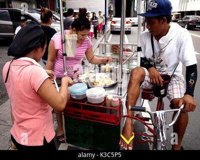 MARIKINA CITY, Philippinen - 28. AUGUST 2017: Ein Mann verkauft Snack food Items auf seinem rollenden Store entlang einer Straße in Marikina City, Philippinen. Stockfoto