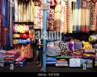 MARIKINA CITY, Philippinen - 28. AUGUST 2017: ein Anbieter verkauft bunt sortiert Fenster Vorhänge in ihrem Speicher auf einem öffentlichen Markt. Stockfoto