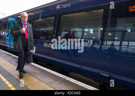 Business Pendler Spaziergänge neben einem Südöstlichen am Bahnhof Ashford International Station stationiert, Kent Stockfoto