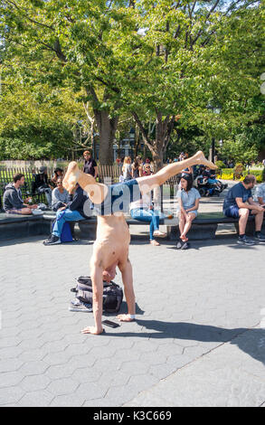 Junge Mann in Shorts macht einen Handstand im Washington Square Park in Greenwich Village Stockfoto