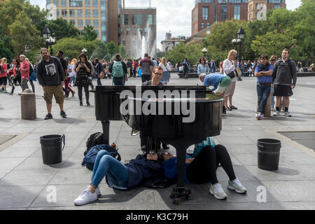 New York, NY USA 2 September 2017 - Colin Huggins sein Baby Grand Piano spielen unter dem Arch im Washington Square Park, am Labor Day Wochenende. Ein paar Touristen beobachten seinem Klavier von unten. © Stacy Walsh Rosenstock Stockfoto