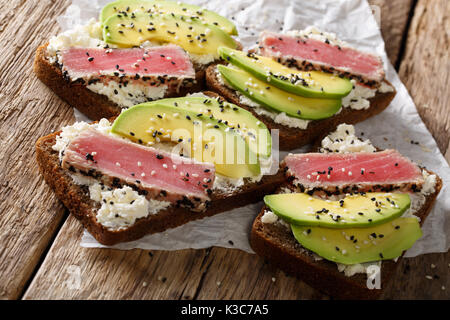 Super Essen: Sandwiches mit Thunfisch Steak in Sesam, Avocado und Hüttenkäse close-up auf den Tisch. Horizontale Stockfoto