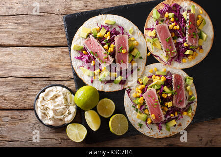Tortilla mit Thunfisch Steak, Sesam und frisches Gemüse close-up auf den Tisch. Draufsicht von oben horizontal Stockfoto