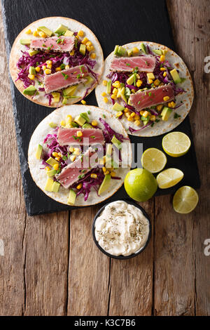 Tacos mit Thunfisch Steak und frischem Gemüse close-up auf den Tisch. Draufsicht von oben vertikal Stockfoto