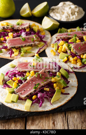Tortilla mit Thunfisch Steak, Sesam und frisches Gemüse close-up auf dem Tisch. Vertikale Stockfoto